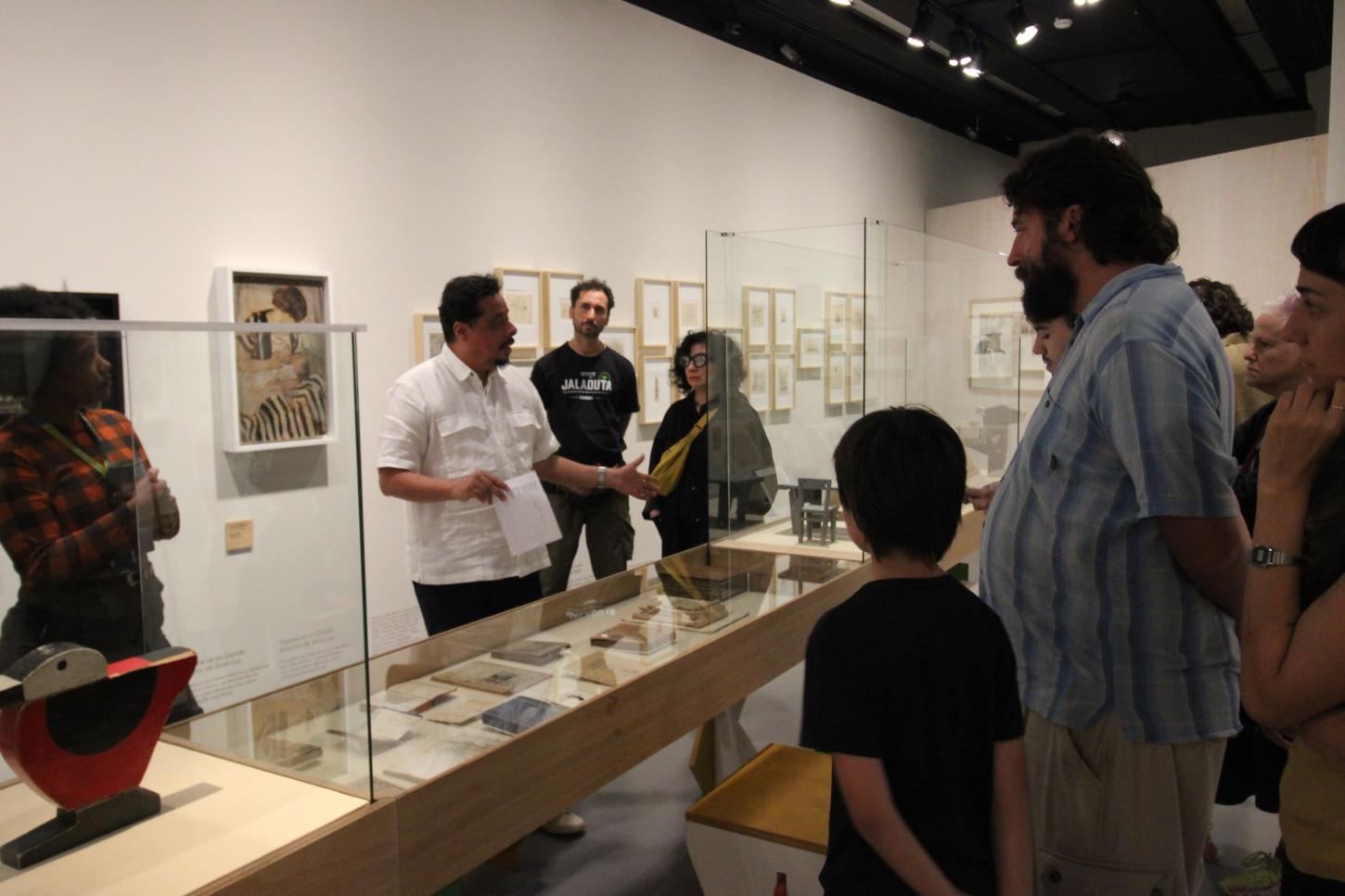 Saulo di Tarso, curador da exposição e artista, em fala para visitantes convidados em sala no 4° andar da exposição aos 150 anos de Joaquín Torres García. Foto: Junior Vieira (Mundo GTV).